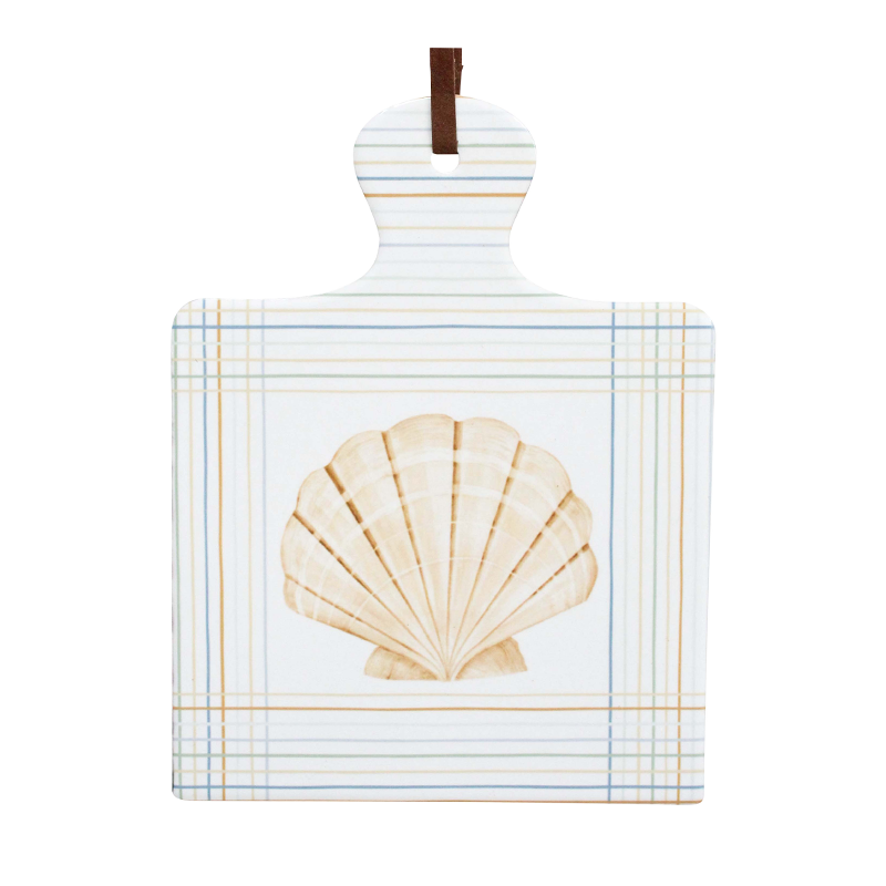 white square trivet decorated with a shell and lines