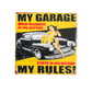 Vintage-style sign with a car and woman, text 'My Garage, What happens in my garage.