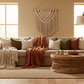 Cozy living room with a beige sofa, decorative pillows, and a woven coffee table.