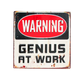 Vintage-style coaster with 'Warning: Genius at Work' text on a white background