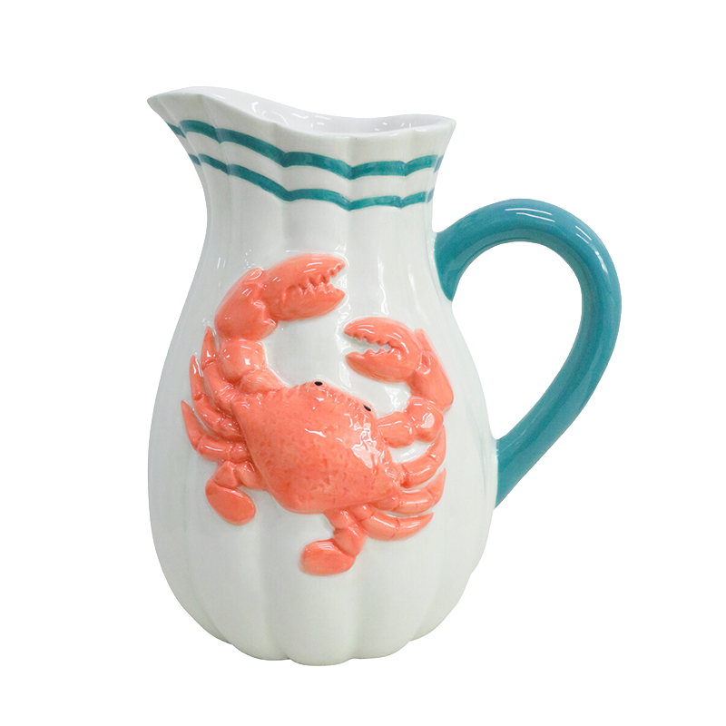 White pitcher with a pink crab design and blue handle 