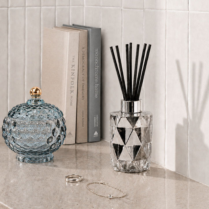 Decorative diffuser with geometric design on a tiled wall background