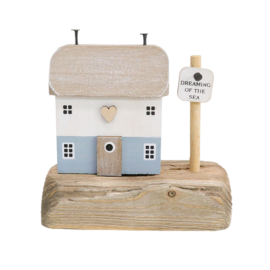 Decorative house on a wooden base with a sign reading 'Dreaming of the Sea' 