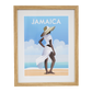 Framed artwork of a woman in a white dress and sun hat on a beach with 'Jamaica' text.