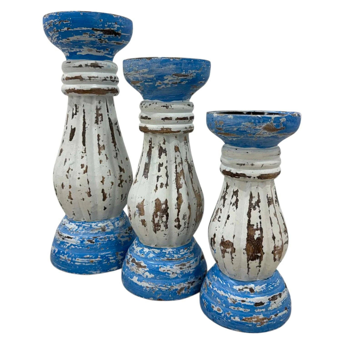 Three distressed wooden candle holders in a tiered arrangement, featuring a blue and white paint finish with visible brown wood grain underneath, set against a plain white background.