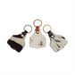 Three cowhide keychains with leather loops on a white background