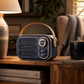 Navy 1960s-inspired Bluetooth speaker with tan carry handle, front speaker grille and gold-tone dial. placed in a snug