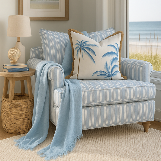 Dusty blue organic cotton muslin throw draped over a striped coastal armchair