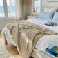Natural organic cotton and bamboo waffle throw layered across a white bed