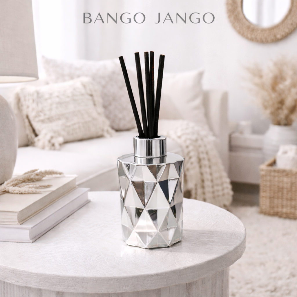 Decorative diffuser with black sticks on a white table in a living room setting, featuring 'Bango Jango' branding.