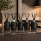 Set of black textured diffusers on a marble surface with decorative elements.
