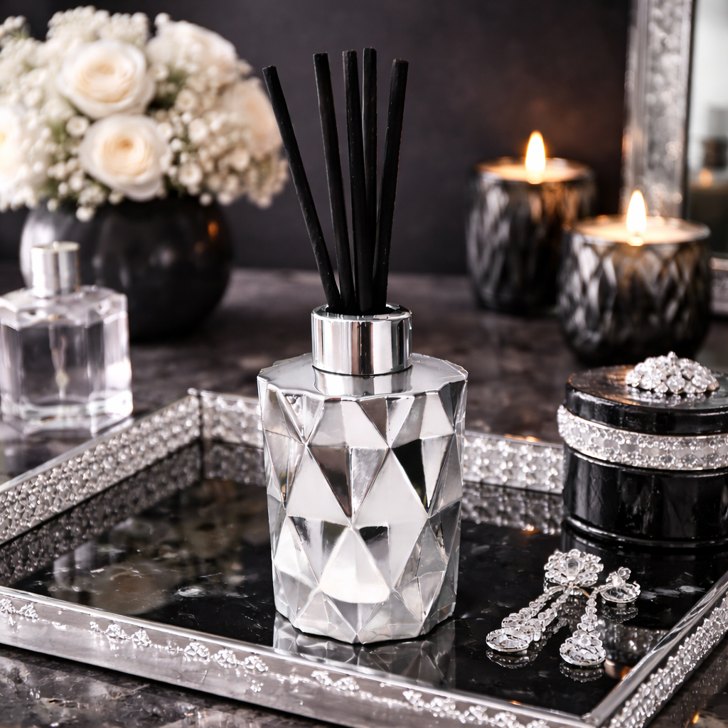 Decorative diffuser bottle on a tray with candles and flowers in the background