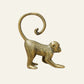 Gold solid brass monkey sculpture in a crouching pose with a curled tail.