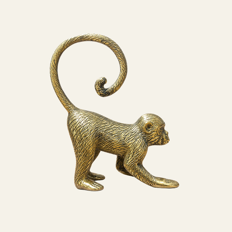 Gold solid brass monkey sculpture in a crouching pose with a curled tail.