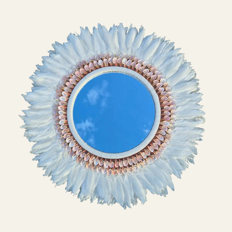 Round feather and shell wall hanging with a blue centre, blush shell ring and pale blue-white feather edge.
