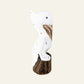 A hand-carved wooden pelican figurine,  painted white with a dark brown natural wood base and carved wood details.