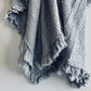 Close-up of the light grey waffle weave and softly frayed ruffle edge
