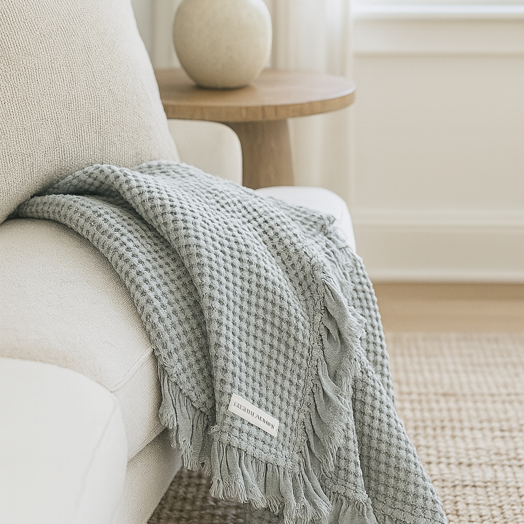 Light grey rustic waffle cotton throw draped over a cream sofa