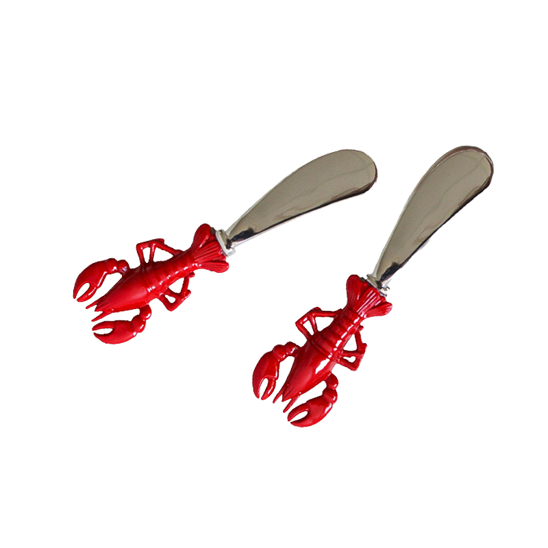 Two red lobster-shaped butter knives on a white background