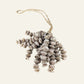 Natural shell cluster hanging made from layered small seashell strands on a loop of natural twine.