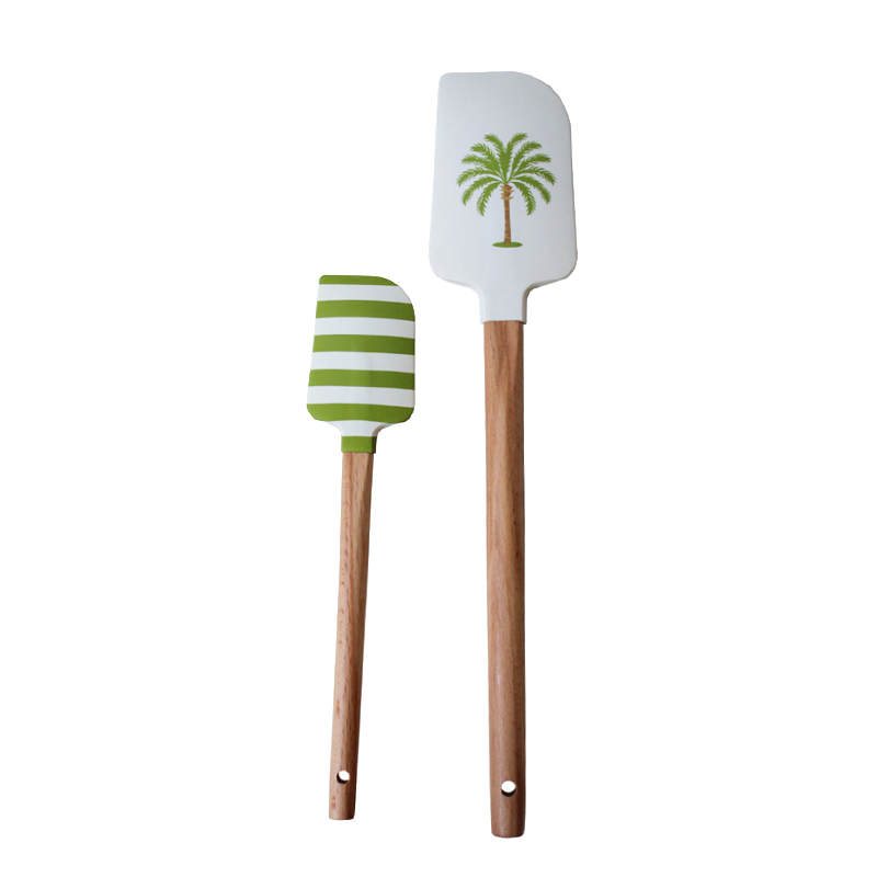 Two spatulas with wooden handles and green accents on a white background