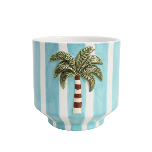 Ceramic plant pot holder with a palm tree design on a blue and white striped background