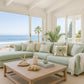 Living room with ocean view, light green sofa, wooden coffee table, and decorative items.