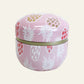 Pastel pink metal trinket tin with white and coloured pineapple print and gold-tone lid.