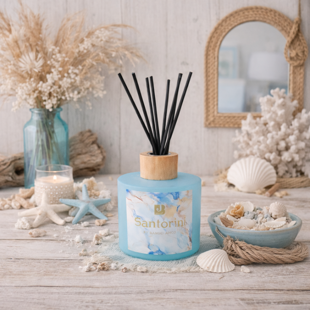 Blue diffuser with black reeds on a decorative table with seashells and starfish.