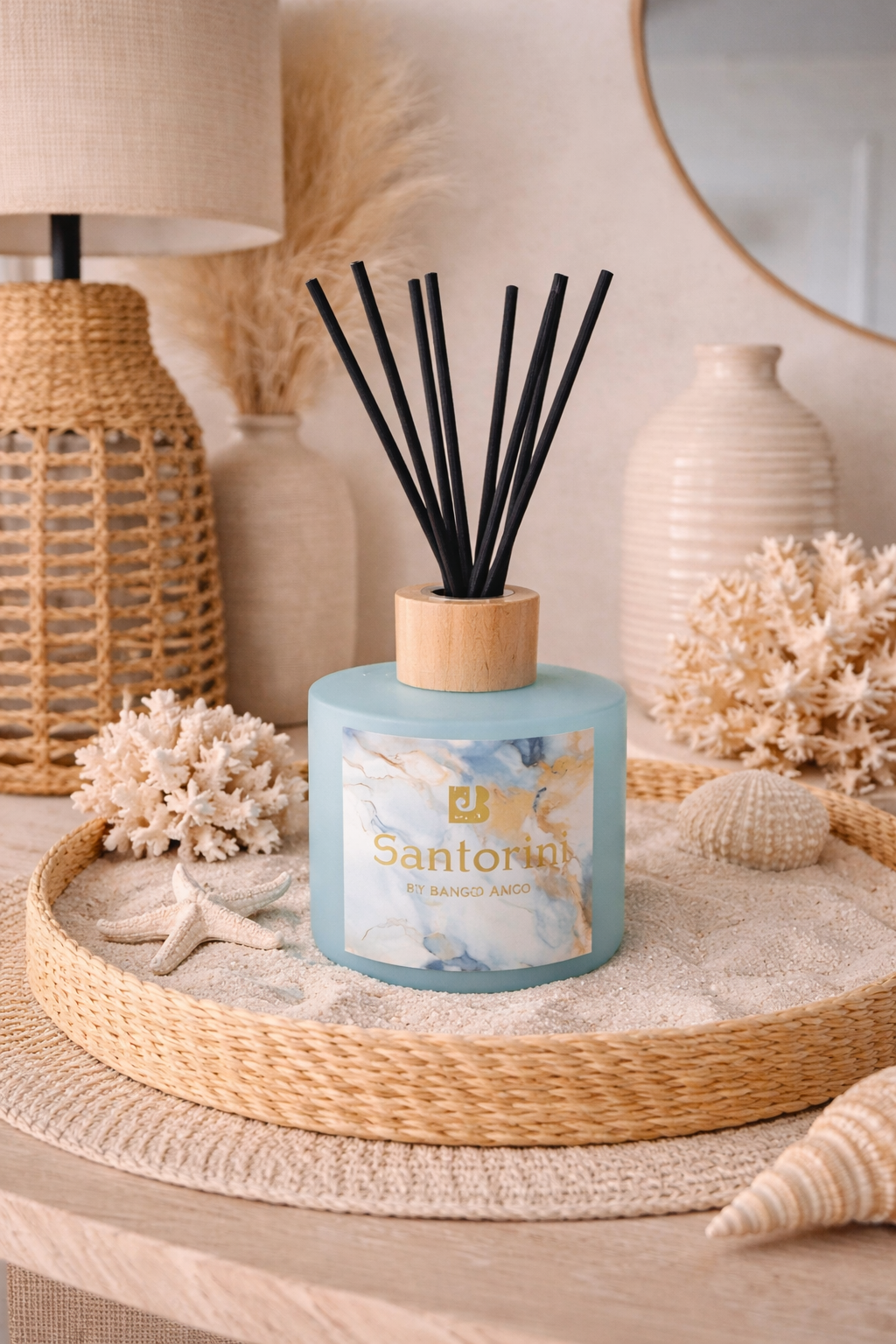 Scented diffuser with black reeds on a decorative table with coastal elements.
