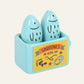 Blue sardine shaped salt and pepper shakers in a holder with a 'Sardines in Olive Oil' label 
