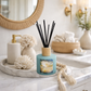 Diffuser with reeds on a decorative tray in a bathroom setting