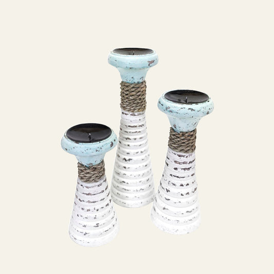 Set of three white painted timber candle holders in graduated heights with pale sage rims and natural seagrass rope detail.