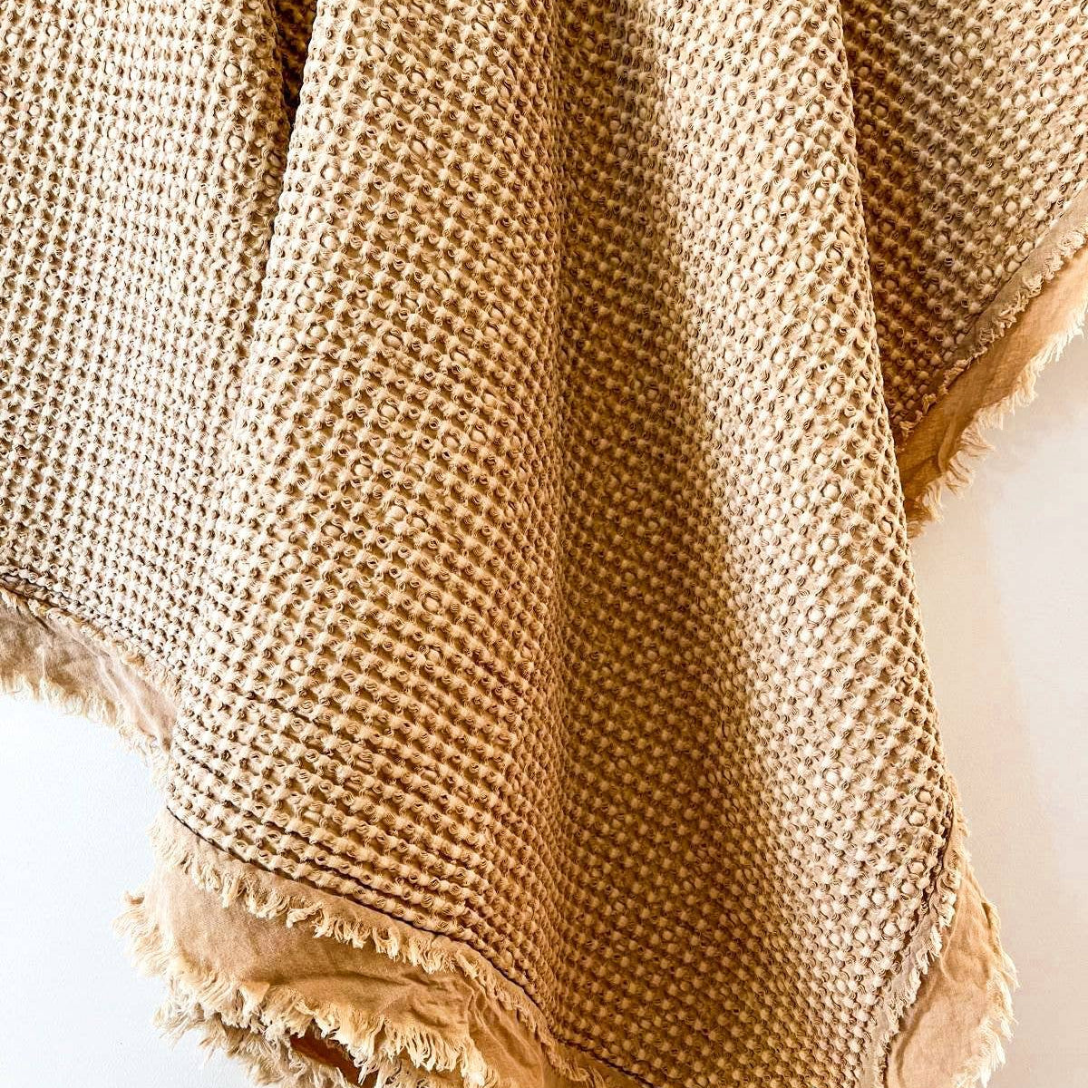 Close-up of light rust cotton waffle weave and frayed edge detail