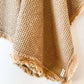 Close-up of the light rust cotton waffle weave and softly frayed edge