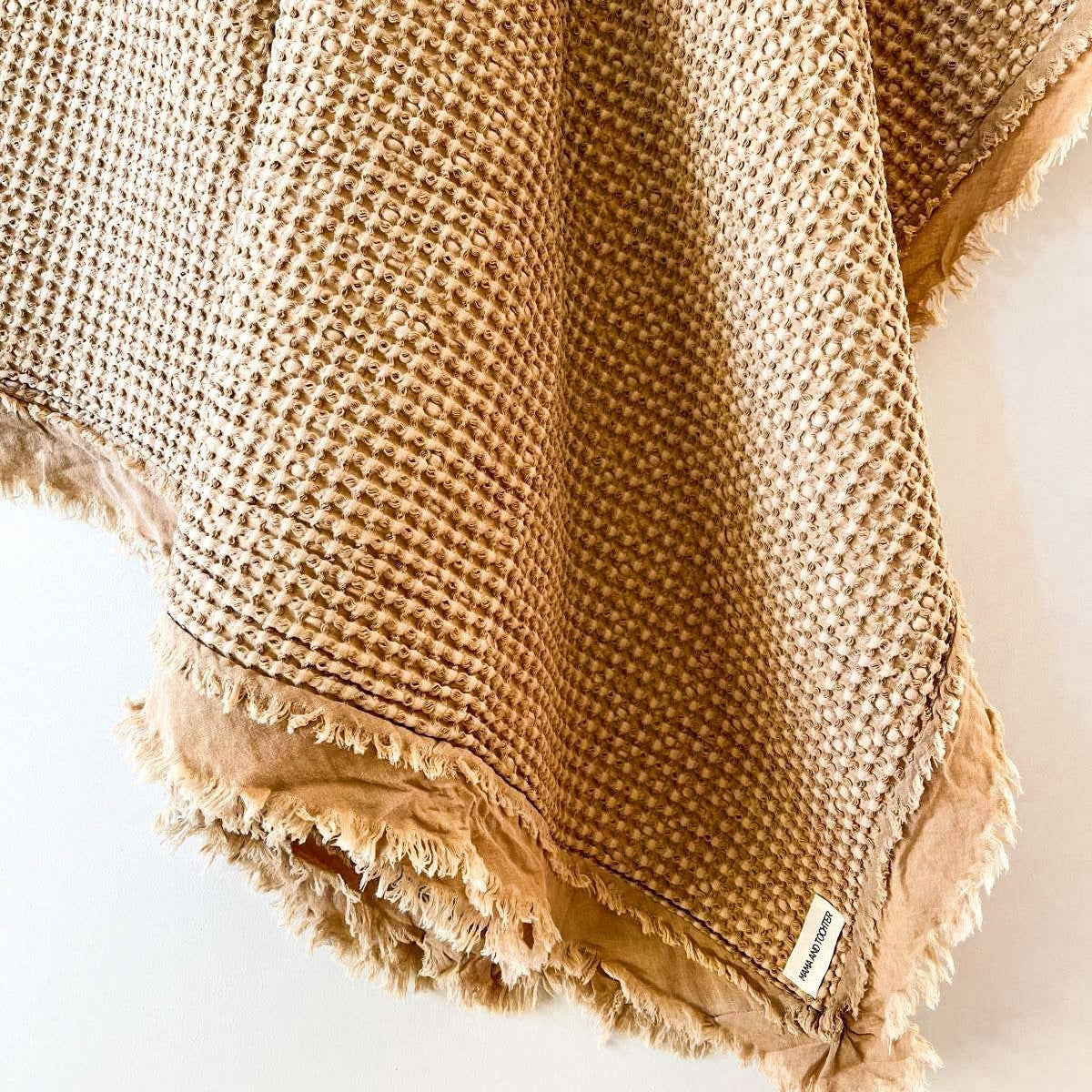 Close-up of the light rust cotton waffle weave and softly frayed edge