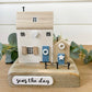 Decorative wooden house sculpture with 'seas the day' text on a white background