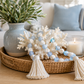 Decorative tray with coral, beads, and a candle on a table