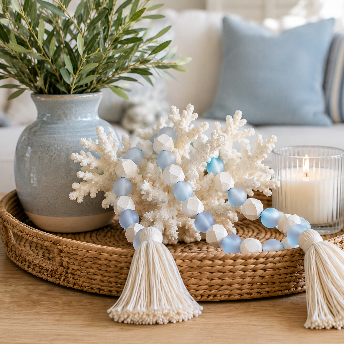Decorative tray with coral, beads, and a candle on a table