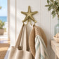 Antique-gold textured starfish wall hook with two curved hooks. in a beach side setting