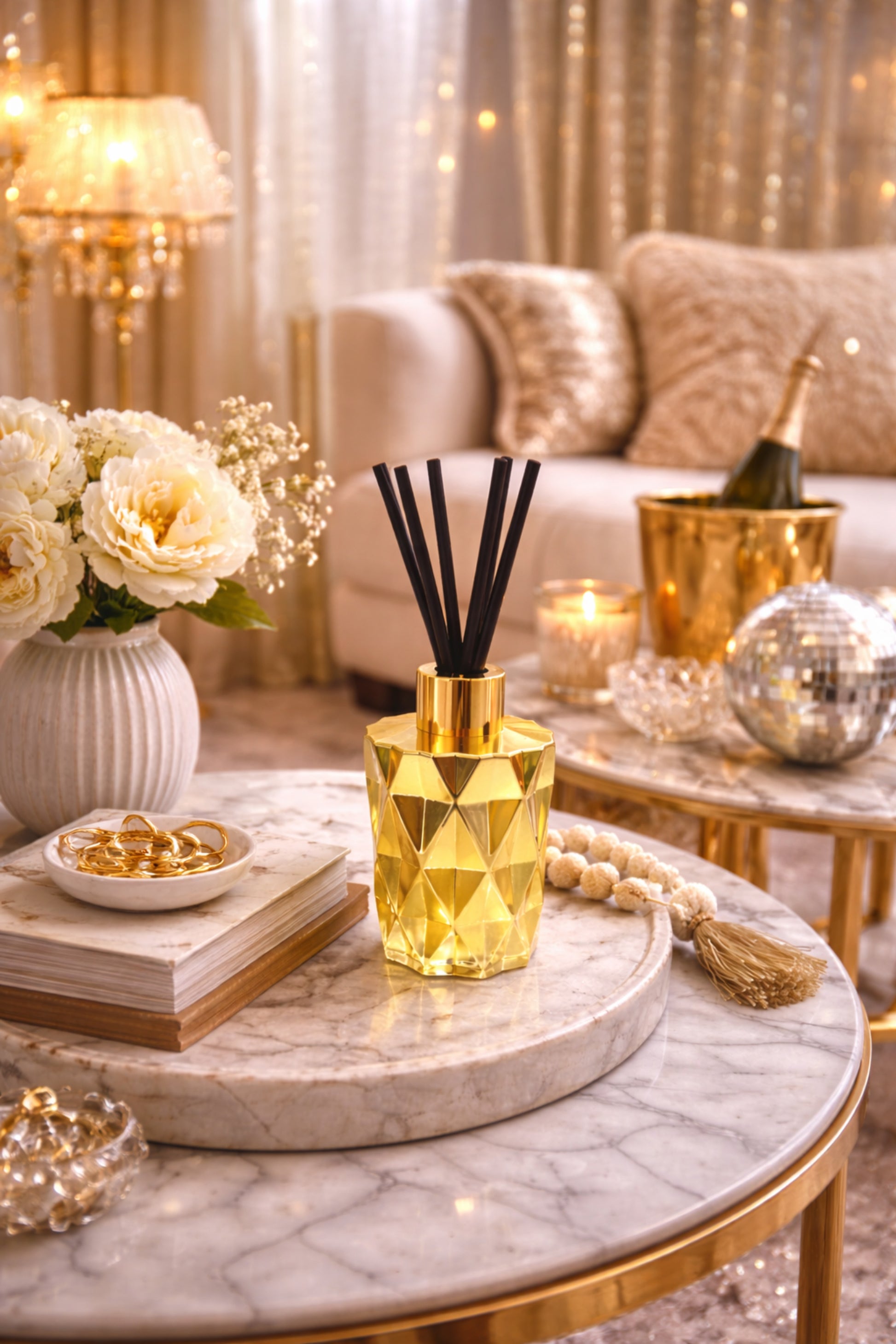 Gold geometric diffuser on a marble table with decorative items in a luxurious living room.
