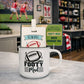 White mug with 'Footy Mad' design on a table, with packaging labeled 'Men's Republic' in the background.