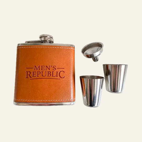 A men's flask set with a brown leather-look flask, silver metal cap, and two stainless steel shot glasses on a white background. The flask is embossed with the text 'MEN'S REPUBLIC'.