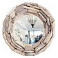 Round driftwood mirror with a rustic frame made of stacked natural wood logs, shown against a plain white background.