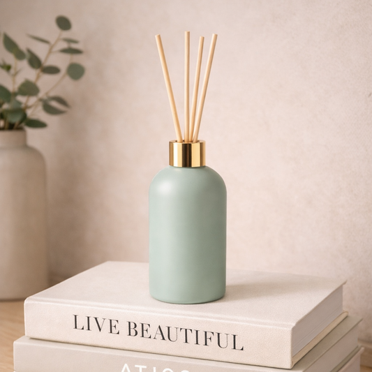 Green diffuser bottle on a stack of books with a neutral background