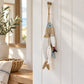 Wooden fish wall hanging on white timber panelling beside a coastal console with a woven basket and neutral linen.