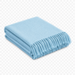 Folded light blue blanket with fringed edge 